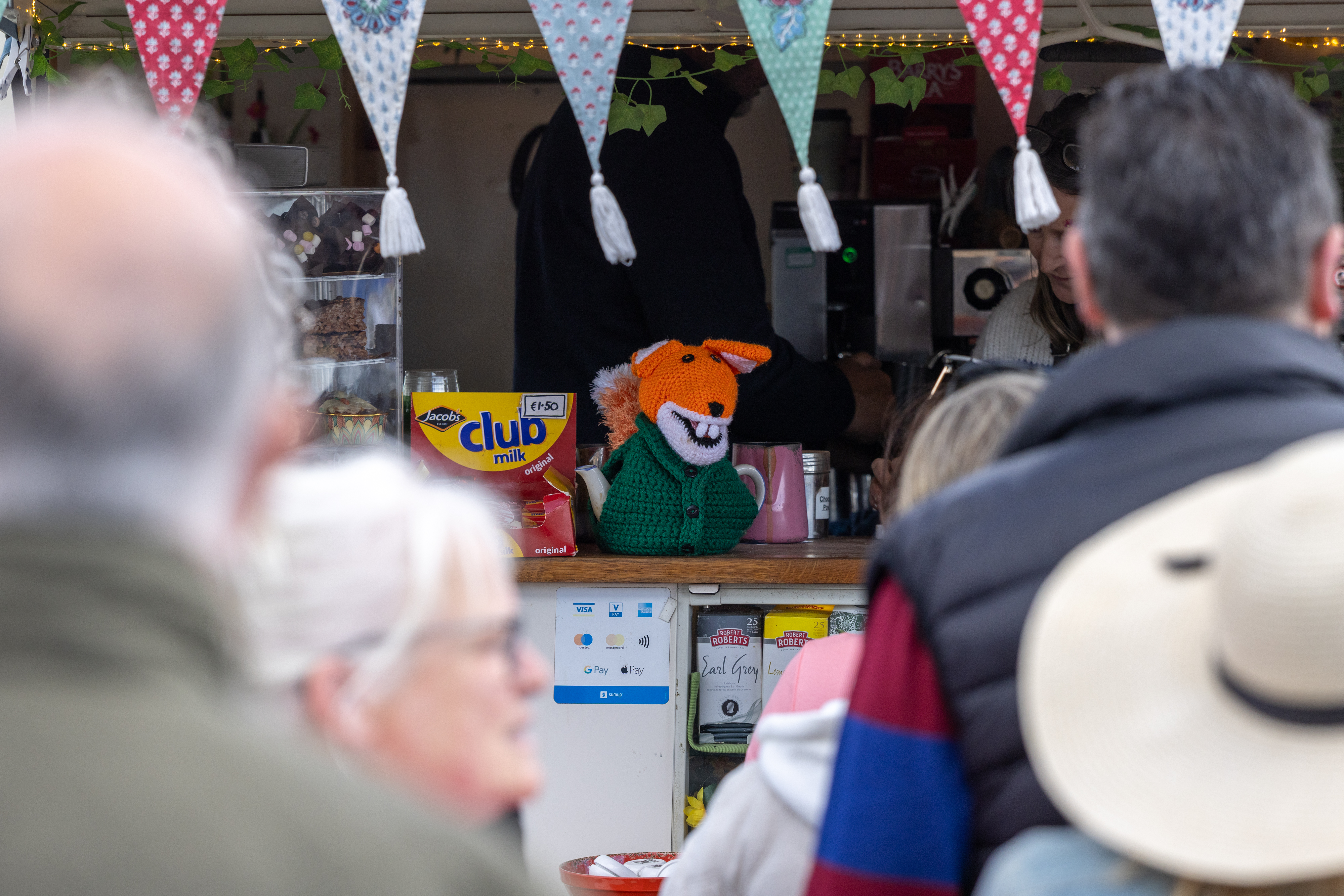 Fox tea cozy on the counter of a coffee stall. 